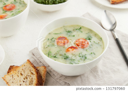 Two bowls of Portuguese style soup Caldo Verde with bread on white background Two bowls of Portuguese style soup Caldo Verde with bread on white background 131797060