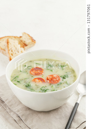Bowl of Portuguese style soup Caldo Verde with bread on white background 131797061