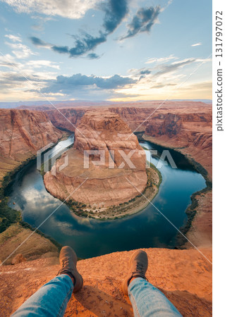 Person sits at Horseshoe Bend, Arizona, enjoying the sunset view 131797072