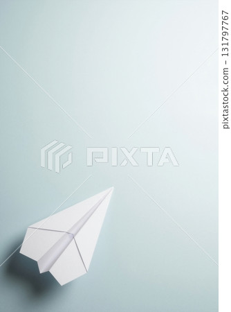 A white paper airplane on a light blue background. Business startup, launch, and travel concept. Minimalist top view with copy space A white paper airplane on a light blue background. Business startup, launch, and travel concept. Minimalist top view with copy space 131797767