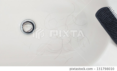 Male hair loss and thinning hair with shedding in bathroom sink 131798010