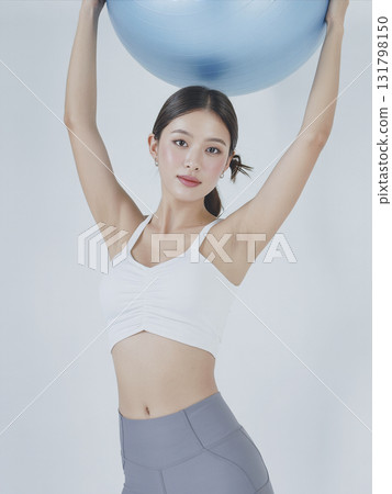 Woman is holding a blue ball Woman is holding a blue ball 131798150