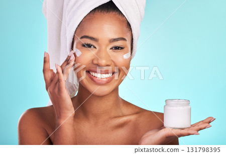 Skincare, beauty and portrait of black woman with cream, towel and smile in bathroom routine or skin glow on blue background. Cosmetics, facial and African model with lotion product in hand in studio Skincare, beauty and portrait of black woman with cream, towel and smile in bathroom routine or skin glow on blue background. Cosmetics, facial and African model with lotion product in hand in studio 131798395
