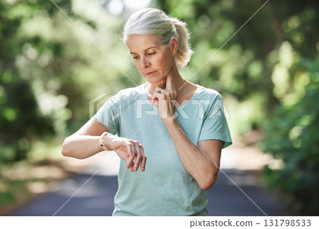 Senior woman, watch and pulse outdoor for exercise on run, workout and training on road for fitness. Elderly female person check cardio progress time for health and wellness while running in nature Senior woman, watch and pulse outdoor for exercise on run, workout and training on road for fitness. Elderly female person check cardio progress time for health and wellness while running in nature 131798533