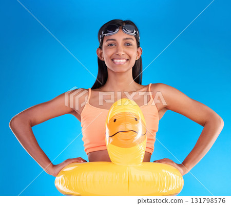 Happy, pool float and portrait of woman in studio for summer, swimming and holiday. Smile, happiness and beach vacation with female and duck inflatable on blue background safety, playful and funny 131798576