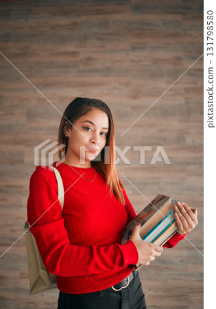 Serious, books and education with portrait of woman on wall background for learning, college and scholarship. University, knowledge and academic with female student for school, intelligent and campus Serious, books and education with portrait of woman on wall background for learning, college and scholarship. University, knowledge and academic with female student for school, intelligent and campus 131798580