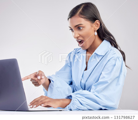Shock, laptop and a pointing business woman in shock on a white background in studio while working. Wow, computer and hand gesture with a surprised female employee looking at an online notification Shock, laptop and a pointing business woman in shock on a white background in studio while working. Wow, computer and hand gesture with a surprised female employee looking at an online notification 131798627