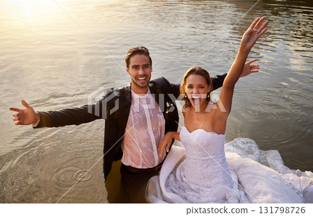 Lake, portrait of wet bride and groom standing in water together with excited smile and playful romance. Love, marriage and happy couple celebrate romantic, loving relationship and wedding in nature. 131798726