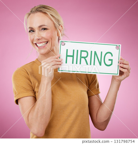 Hiring, sign and portrait of a woman for recruitment, job search and advertising opportunity. Smile of a happy business person with a poster for recruiting and human resources on a pink background 131798754