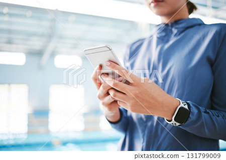 Hands, phone and athlete texting at swimming pool for social media, web scrolling or online browsing after exercise. Swim sports, cellphone and woman typing on internet chat after workout or training 131799009