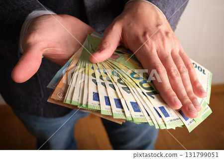 Close-up of euro banknotes in a man's hands. Selective focus. 131799051
