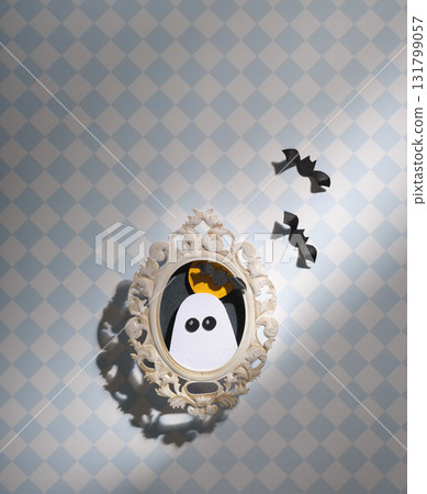 Handmade Halloween craft. Portrait of a ghost against a backdrop of the moon and bats, hanging on a wall with checkered wallpaper. Copyspace Handmade Halloween craft. Portrait of a ghost against a backdrop of the moon and bats, hanging on a wall with checkered wallpaper. Copyspace 131799057