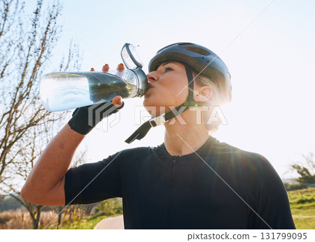 Woman drinking water, bottle and cycling with fitness outdoor, helmet for safety and health with hydration. Athlete, biking and female with healthy and active lifestyle, wellness and sports training 131799095
