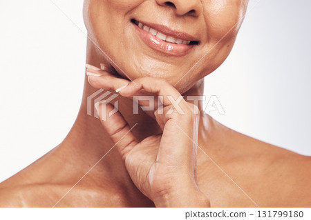 Hand, mouth and beauty with a mature woman in studio for skincare, anti aging treatment or cosmetics. Skin, facial and wellness with a senior female touching her face for self care or hygiene closeup 131799180