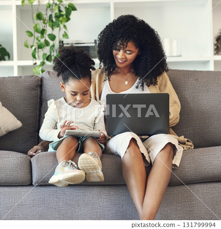 Laptop, tablet and black family online for learning, remote work or education in home living room. Woman or mother and girl child together on couch with internet for games or to watch movie and relax 131799994