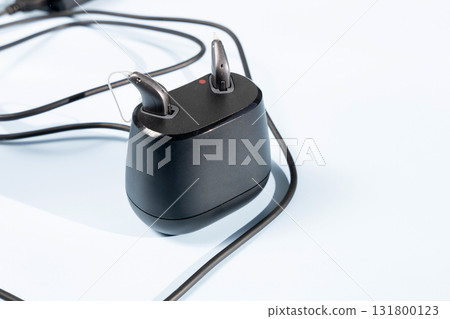 Modern hearing aid in the charginng dock Modern hearing aid in the charginng dock 131800123