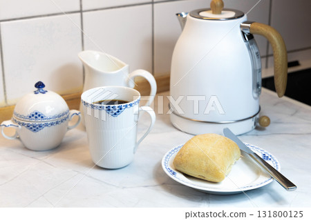 Breakfast served on the kitchen table with fresh bread and coffee Breakfast served on the kitchen table with fresh bread and coffee 131800125