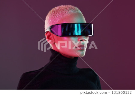Woman, vr and metaverse augmented reality glasses for futuristic gaming and technology. Cyberpunk person on studio background with digital headset for 3d and cyber world robot fantasy user experience Woman, vr and metaverse augmented reality glasses for futuristic gaming and technology. Cyberpunk person on studio background with digital headset for 3d and cyber world robot fantasy user experience 131800132
