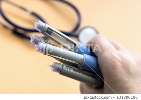 Women's hands holding Insulin injection pen for diabetics and weight loss. 131800196