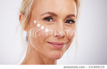 Skincare, portrait and face cream for mature woman in studio for wellness, beauty and care on grey background. Facial, product or sunscreen by lady relax in luxury, cosmetic and lotion while isolated 131800219
