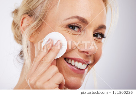 Mature, facial and cotton in studio for skincare, wellness and cleaning routine on grey background. Face, skin and pad by older beauty model relax in luxury, dermatology or cosmetic grooming isolated 131800226