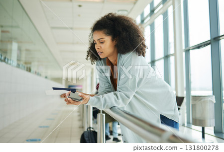 Ticket, airport and passport of black woman for travel, global opportunity and transport time or schedule. UK person with smartphone and identity document in lobby for flight services and immigration Ticket, airport and passport of black woman for travel, global opportunity and transport time or schedule. UK person with smartphone and identity document in lobby for flight services and immigration 131800278
