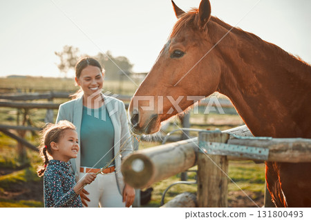 Horse feeding, girl and mother on farm with animal and smile in the countryside outdoor. Pet horses, mama and child with hand holding grass on agriculture field with mom feeling parent love on ranch Horse feeding, girl and mother on farm with animal and smile in the countryside outdoor. Pet horses, mama and child with hand holding grass on agriculture field with mom feeling parent love on ranch 131800493