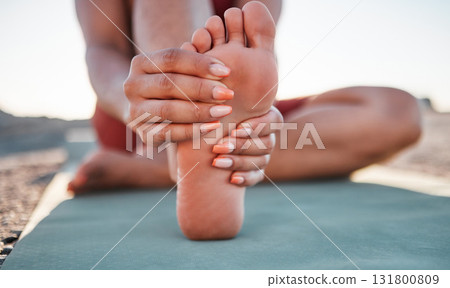 Beach, yoga and woman stretching foot, feet or legs for cardio exercise, outdoor pilates training or body healthcare goals. Nature freedom, calm peace or athlete warm up for fitness workout on ground 131800809