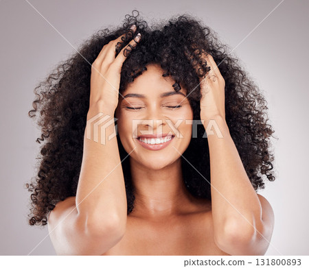 Haircare, beauty and woman with an afro in the studio feeling her hair after a salon treatment. Cosmetic, health and happy female model with a healthy, natural and curly hairstyle by gray background. 131800893
