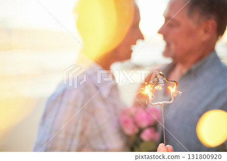 Couple, sparkler and date to celebrate love, birthday and vacation or holiday at beach in summer. Senior man and woman hug outdoor with star and bokeh for sunset dating, marriage or valentines day Couple, sparkler and date to celebrate love, birthday and vacation or holiday at beach in summer. Senior man and woman hug outdoor with star and bokeh for sunset dating, marriage or valentines day 131800920