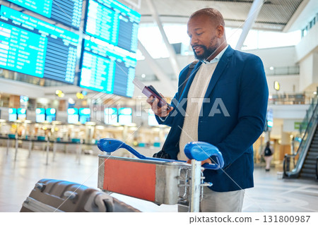 Phone, passport and black man with luggage in airport while on social media or internet browsing. Suitcase, travel and male entrepreneur with trolley, boarding pass and mobile smartphone in airline. 131800987