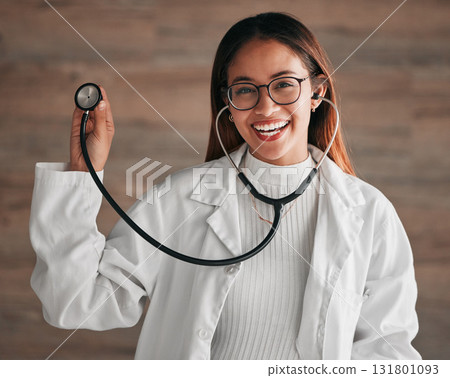 Healthcare, happy and portrait of a doctor with a stethoscope isolated on a clinic wall. Smile, consulting and a woman in medicine for a consultation, cardiology and medical analysis at a hospital 131801093