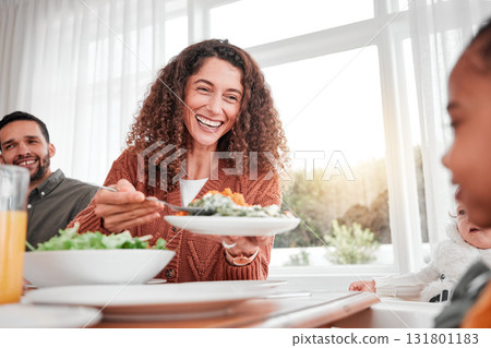 Family dinner, happy woman and salad with children at home for nutrition. Celebration, together and people with kids eating at table with happiness and a smile in a house giving lunch on plate 131801183