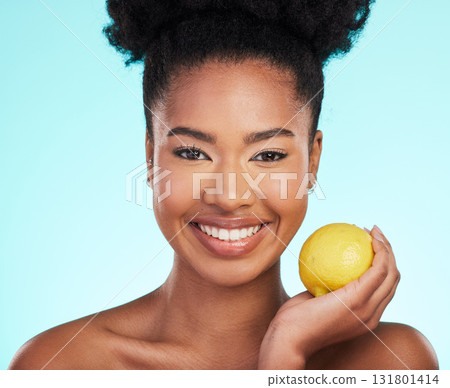 Lemon, skincare beauty and woman portrait of facial, wellness and detox healthcare. Isolated, blue background and studio with a young female feeling happy from healthy food with vitamin c for glow Lemon, skincare beauty and woman portrait of facial, wellness and detox healthcare. Isolated, blue background and studio with a young female feeling happy from healthy food with vitamin c for glow 131801414