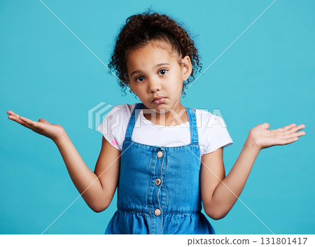 Portrait, children and shrug with a girl on a blue background in studio feeling confused or lost. Kids, question and doubt with a young female child shrugging her shoulders to gesture whatever Portrait, children and shrug with a girl on a blue background in studio feeling confused or lost. Kids, question and doubt with a young female child shrugging her shoulders to gesture whatever 131801417