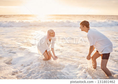 Couple at beach, splash in water with sea, travel and freedom outdoor, love and care in relationship with youth. Cafe free at sunset, nature and ocean waves with young people on holiday in Hawaii 131801462