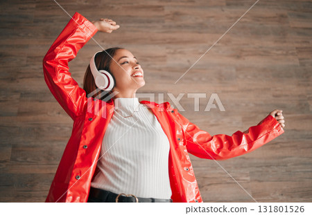 Woman, happiness and dancing with music headphones isolated on a wood background. Freedom, dance and female or person listening, streaming or enjoying audio, radio song or podcast, sound and smile. 131801526