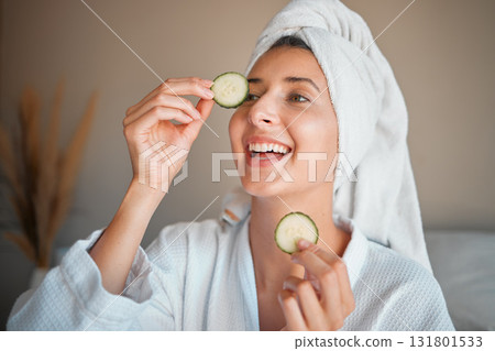 Happy woman, cucumber and natural skincare for beauty, cosmetics or facial treatment at spa. Female smiling and applying vegetable to eyes for organic healthcare, hydration or dermatology at salon Happy woman, cucumber and natural skincare for beauty, cosmetics or facial treatment at spa. Female smiling and applying vegetable to eyes for organic healthcare, hydration or dermatology at salon 131801533