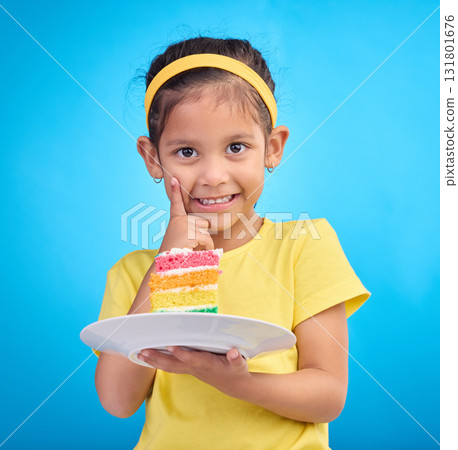 Birthday cake, portrait and young girl with sweet in studio eating icing for party event dessert. Celebration, rainbow food and hungry kid in a isolated and blue background youth ready to celebrate 131801676