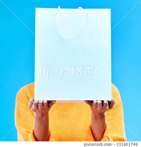 Shopping, bag and hands of woman on blue background for retail discount, deal and store promotion. Commerce mockup, fashion and girl holding package for advertising, sale news and purchase in studio Shopping, bag and hands of woman on blue background for retail discount, deal and store promotion. Commerce mockup, fashion and girl holding package for advertising, sale news and purchase in studio 131801749