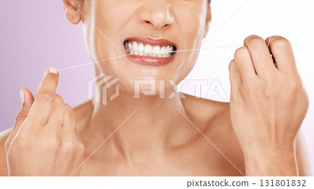 Face, woman and flossing teeth for cleaning, hygiene or tooth care in studio isolated on a purple background. Oral health, fresh breath or mature female model with dental floss or thread for wellness 131801832