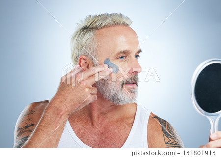 Mirror, skincare and facial with mature man in studio for cleansing, detox and spa treatment. Cosmetics, clay mask and face with senior model on gray background for anti aging, product and natural Mirror, skincare and facial with mature man in studio for cleansing, detox and spa treatment. Cosmetics, clay mask and face with senior model on gray background for anti aging, product and natural 131801913
