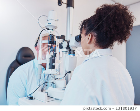 Optometry, eye exam and ophthalmologist testing patient vision or eyes using a slit lamp machine by a doctor. Healthcare, eyecare and medical insurance professional doing a visual examination on man 131801937