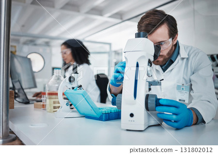 Man, doctor and forensic scientist with microscope for examination, experiment or test at laboratory. Male in science looking at micro organisms for exam, breakthrough or testing to find cure at lab 131802012
