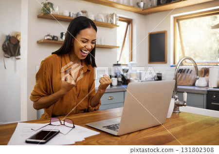 Laptop, success and business woman celebrating finance, savings and investment growth in a kitchen. Online, victory and freelance female excited for good news, loan and startup approval in her home 131802308