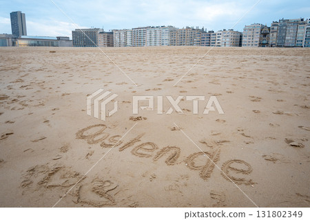 Ostend exclamation word on sea sand. Belgium. Houses, hotel and beautiful walking way. Ostend exclamation word on sea sand. Belgium. Houses, hotel and beautiful walking way. 131802349