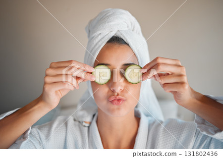 Self care, skincare and woman with cucumber on her face for a organic, cosmetic and natural skin routine. Beauty, vegetable and female doing a spa facial treatment for self love and to relax at home. Self care, skincare and woman with cucumber on her face for a organic, cosmetic and natural skin routine. Beauty, vegetable and female doing a spa facial treatment for self love and to relax at home. 131802436
