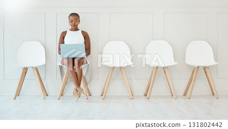 Laptop, black woman and waiting room chair for job interview, recruitment or hiring. Computer, hr and serious business person typing or African female sitting in office for employment in workplace. Laptop, black woman and waiting room chair for job interview, recruitment or hiring. Computer, hr and serious business person typing or African female sitting in office for employment in workplace. 131802442