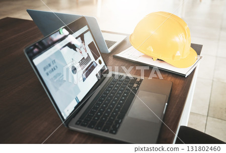 Laptop, hardhat and desk in an industry office for engineering architecture project planning. Industrial, construction and computer or technology for research with a safety helmet in the workplace. 131802460
