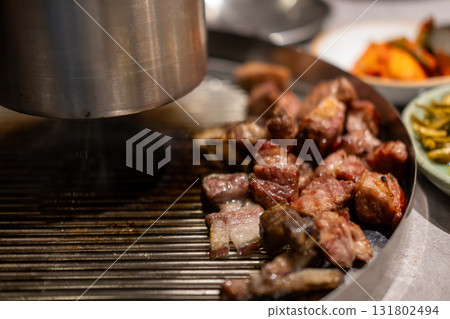 Samgyupsal, a popular Korean dish consisting of thick, sliced pork belly cooked on the grill Samgyupsal, a popular Korean dish consisting of thick, sliced pork belly cooked on the grill 131802494